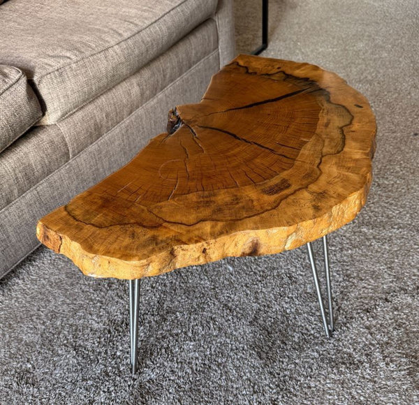 1. Reperch side table with a natural wood slab top and metal hairpin legs beside a beige sofa.