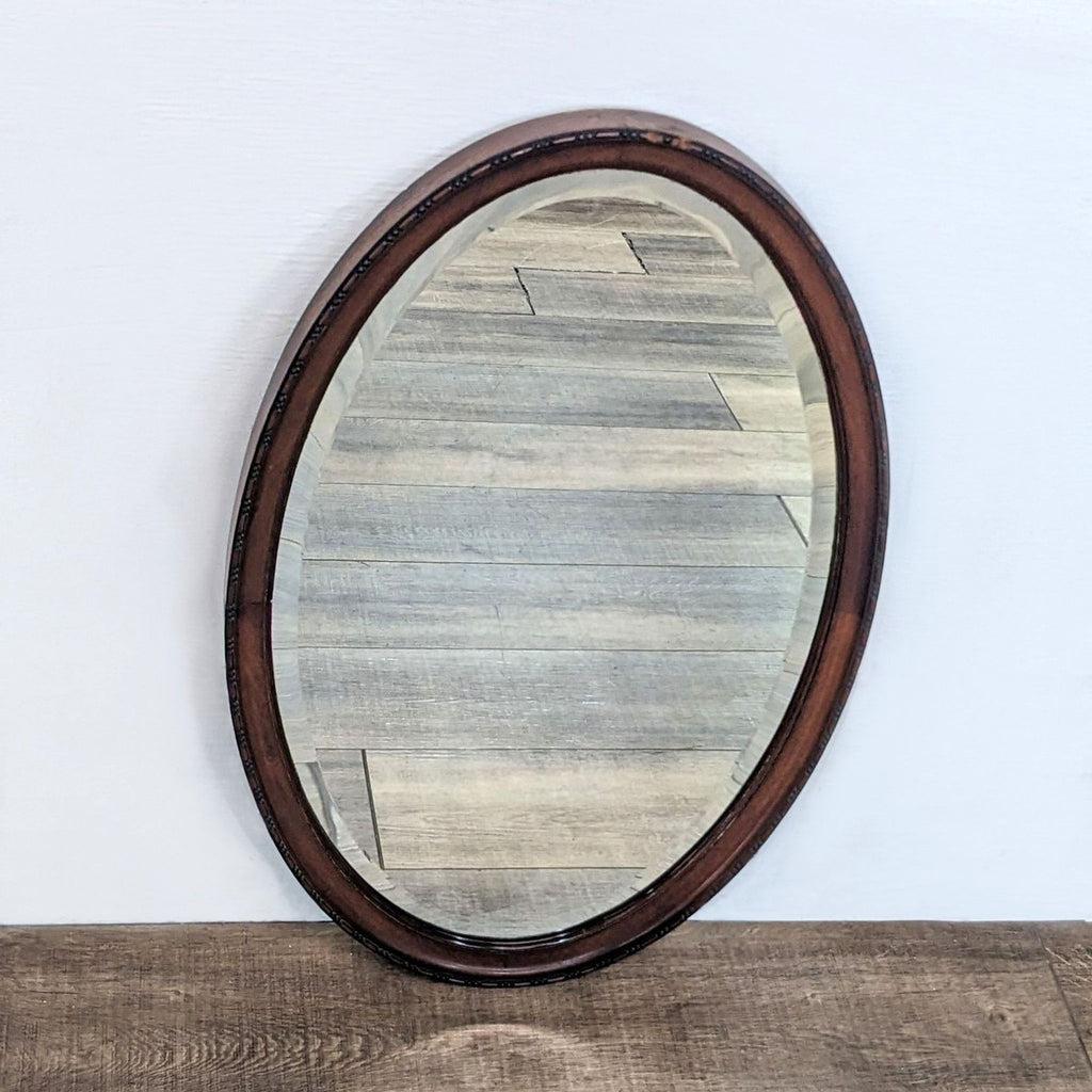 Side angle of oval mirror, wood frame with beaded trim, Reperch brand.