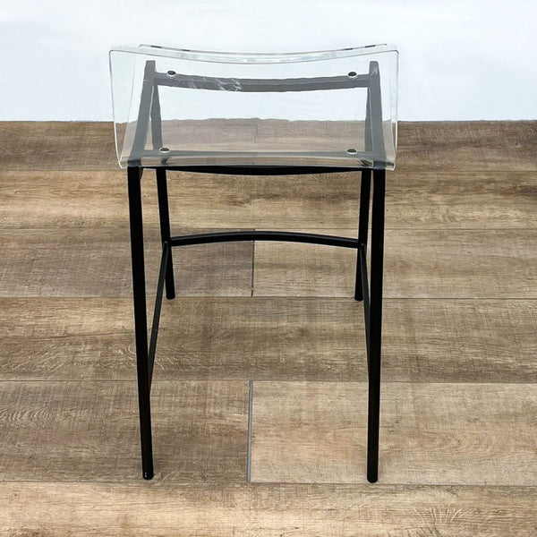 Close-up of a Chiaro stool by CB2 with a clear acrylic seat and black steel legs.