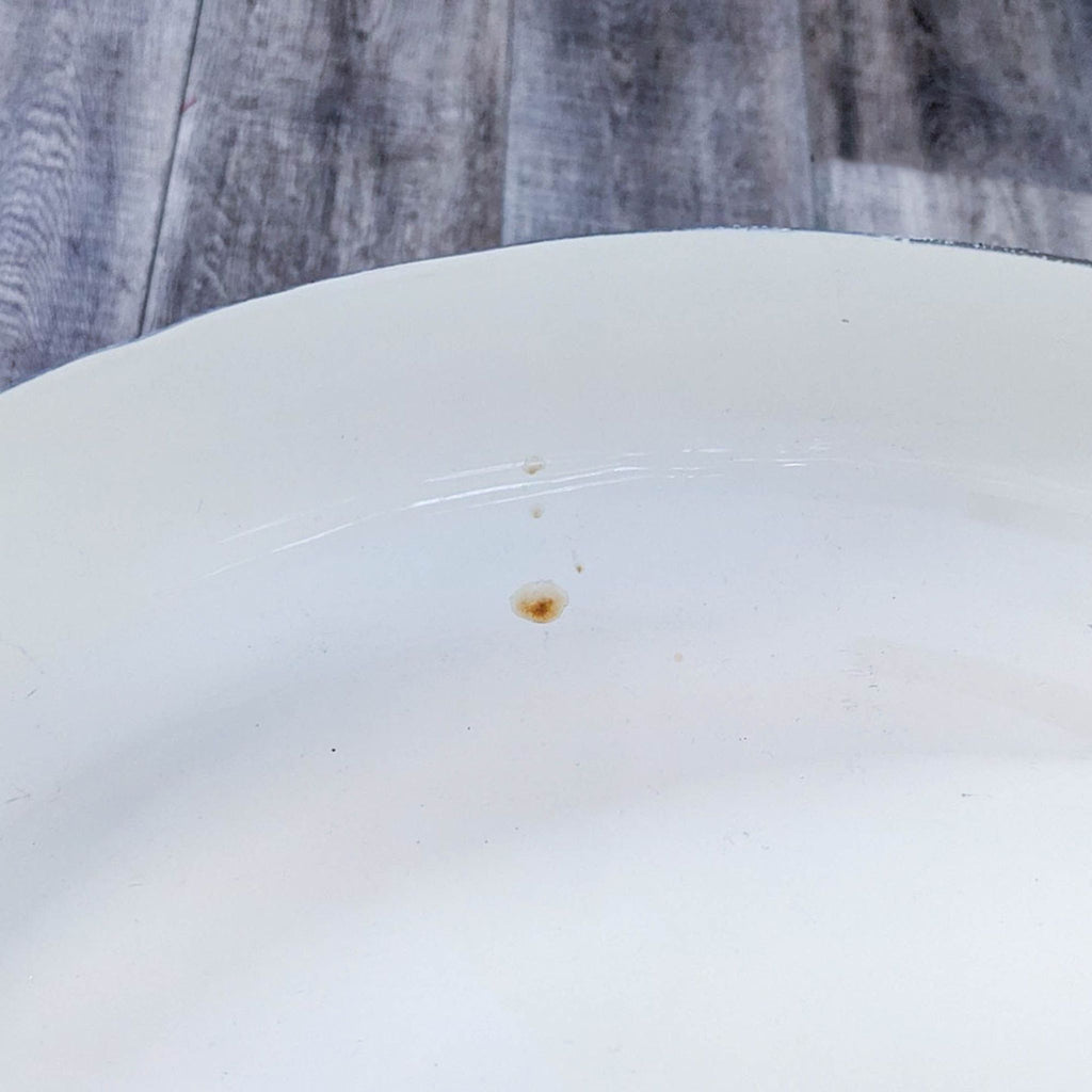 Close-up of enamel surface with minor imperfections on table.