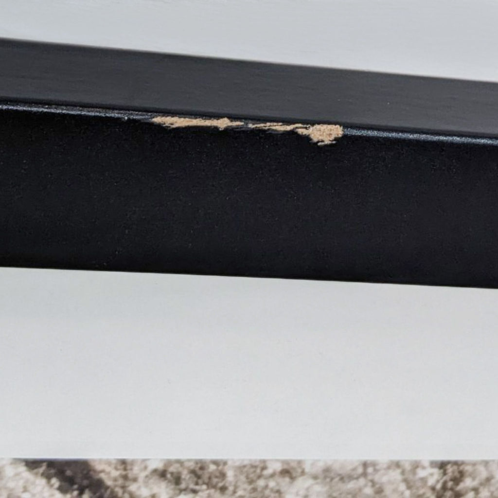 Close-up of a black frame with minor damage.