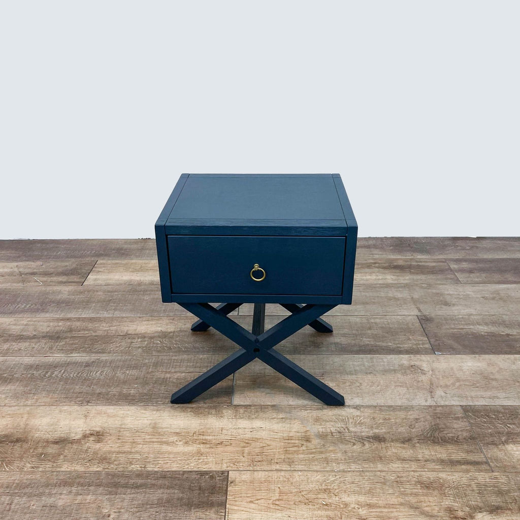 Reperch End Table in blue with cross legs and a single drawer.  