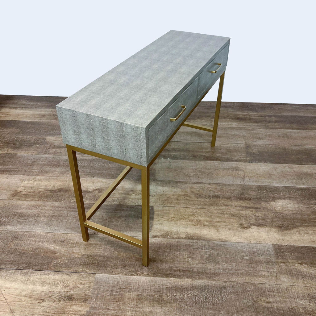 Side view of gray console table on gold metal base.