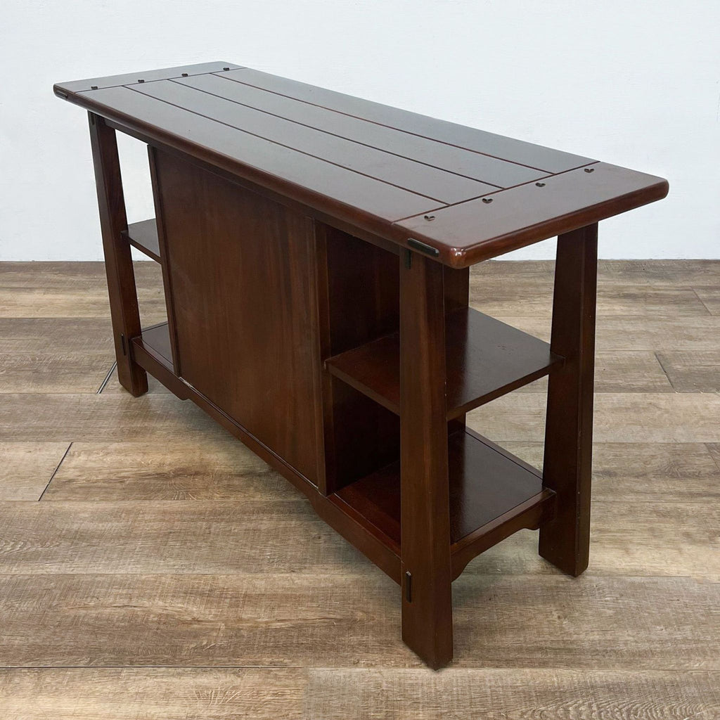 Back view of wooden console table with planked top and shelving.  