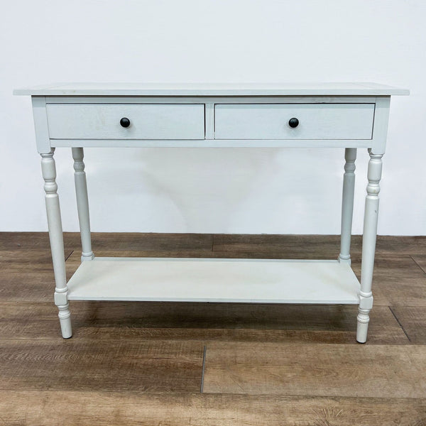 White console table with two drawers and a lower shelf, featuring turned legs.