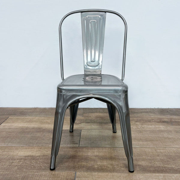 Front view of a metal side chair with a tall, curved back and tapered legs.