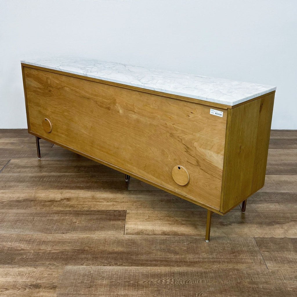 Back view of oak entertainment center with marble top and circular cutouts.
