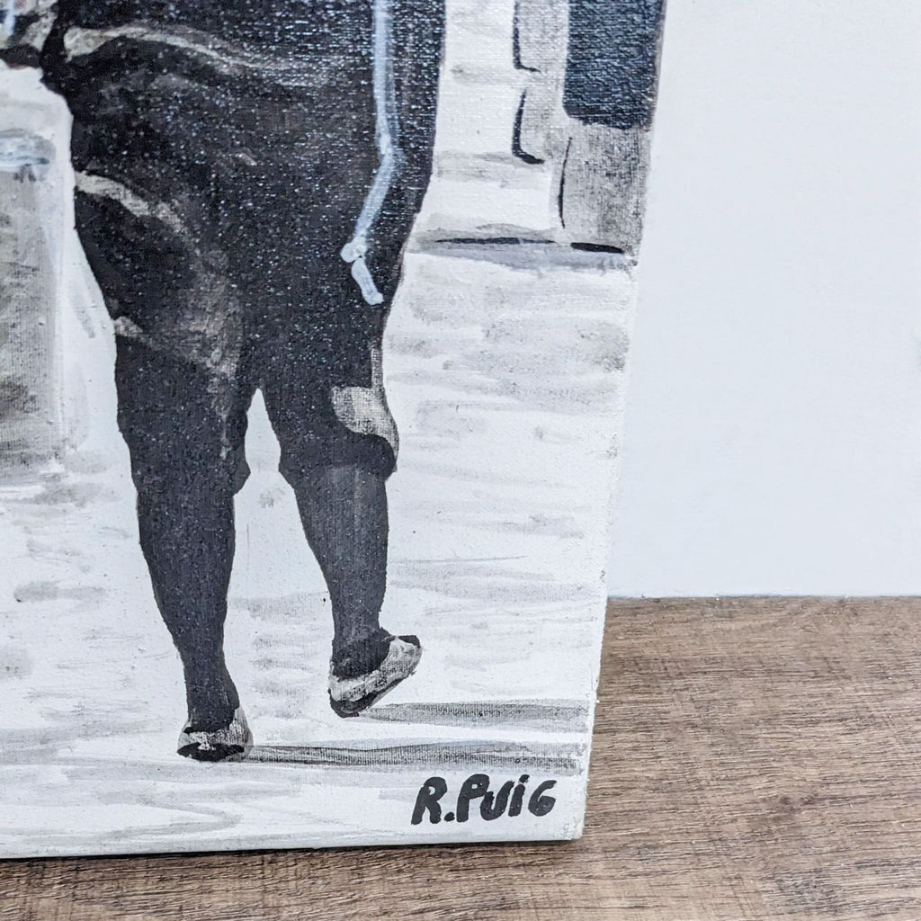 2. Close-up of Roberto Puig’s signature on a black and white canvas painting with a street scene detail.