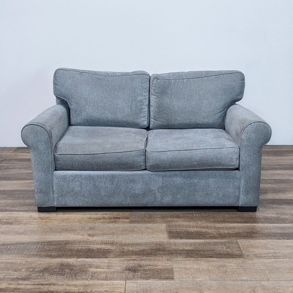 Transitional gray loveseat with rolled arms and dark block feet.