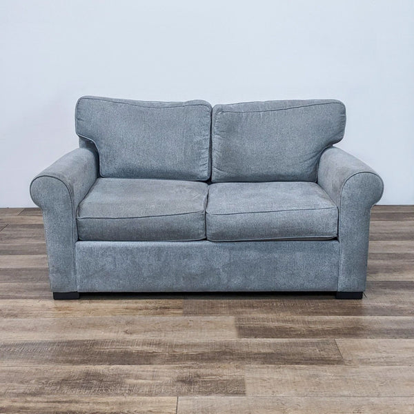Transitional gray loveseat with rolled arms and dark block feet.