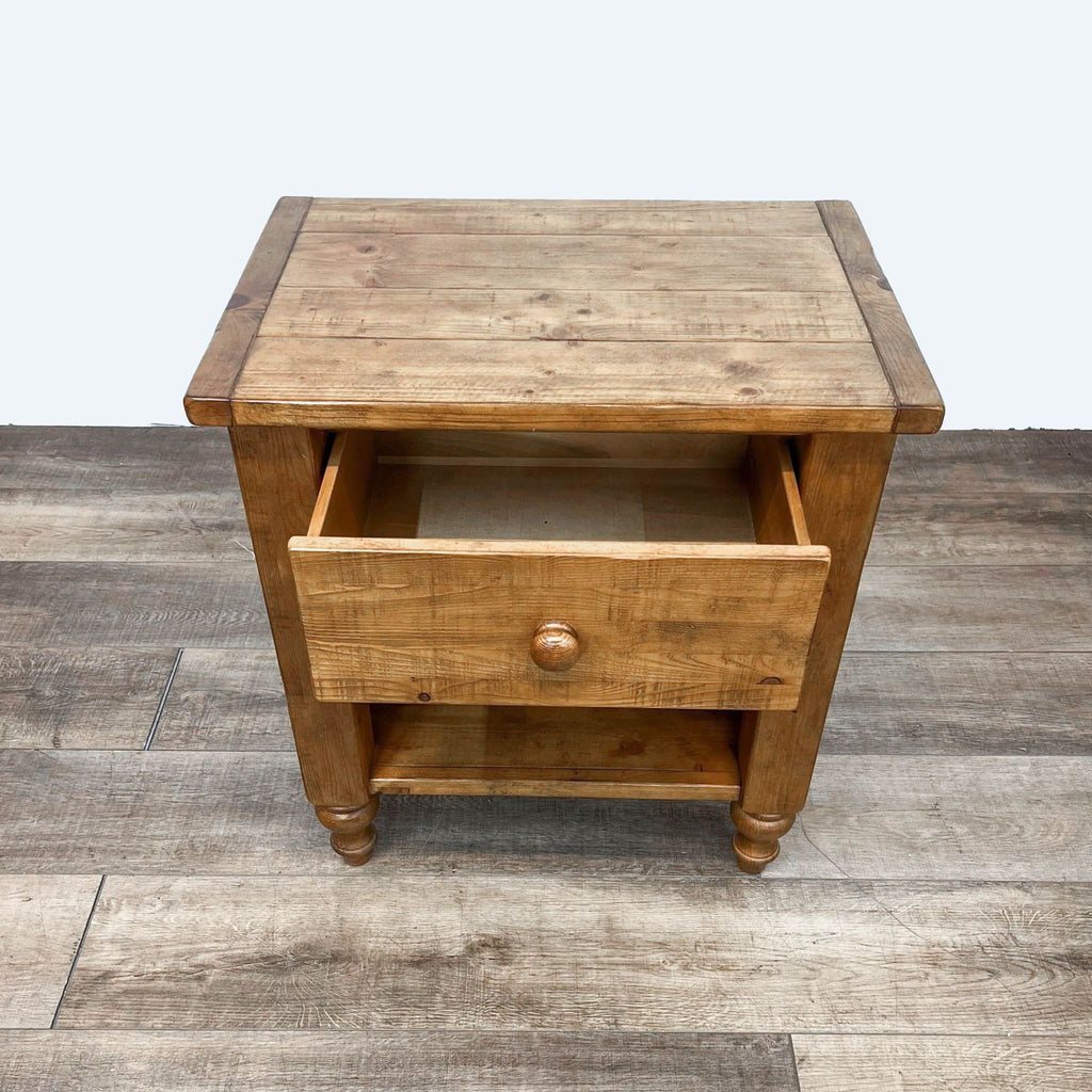 Pottery Barn end table in pine with an open drawer and lower shelf.  