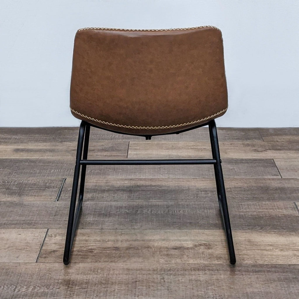 Back view of a Reperch dining chair with decorative stitching on brown faux leather and metal frame.