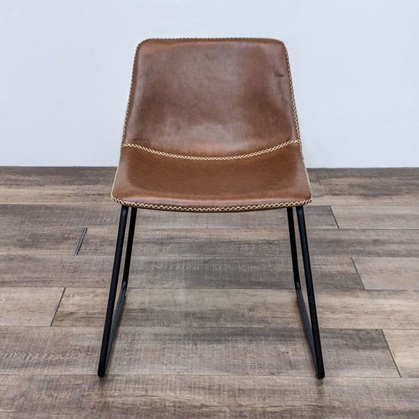 Front view of a brown faux leather dining chair with a bucket seat and metal legs.