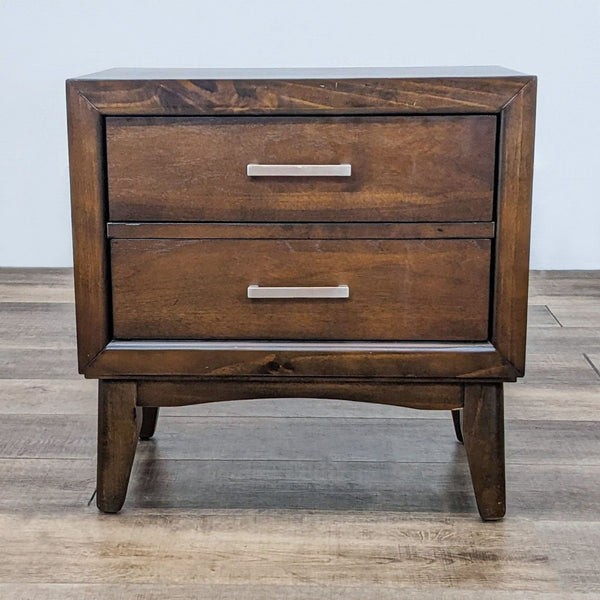 End table with two drawers and metal handles on a wooden floor.