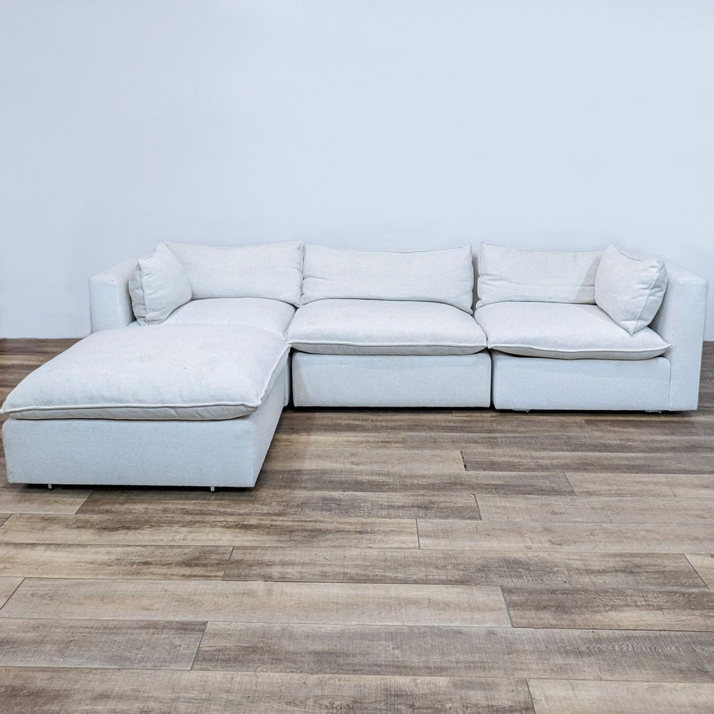 Ivory modular sectional in spacious living room setup on wooden flooring.