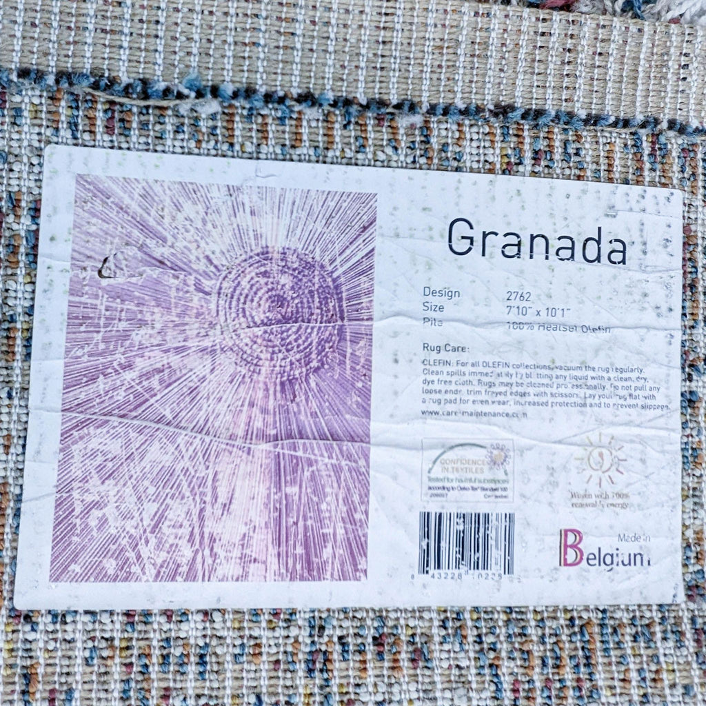 Label on the Granada Ezra Rug, detailing design and care instructions, made in Belgium.