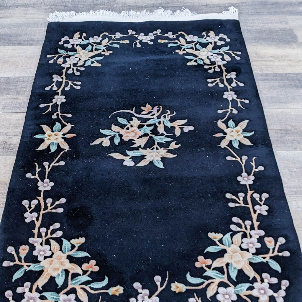 Hand-knotted rug with floral patterns and white fringe, showcasing elegant design by Reperch.