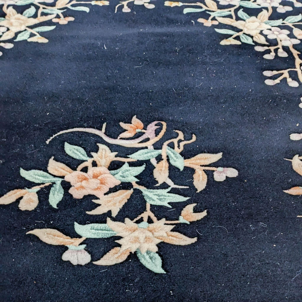 Close-up view of a Floral Oriental rug's intricate detail, showing soft pastel flowers on a dark backdrop.