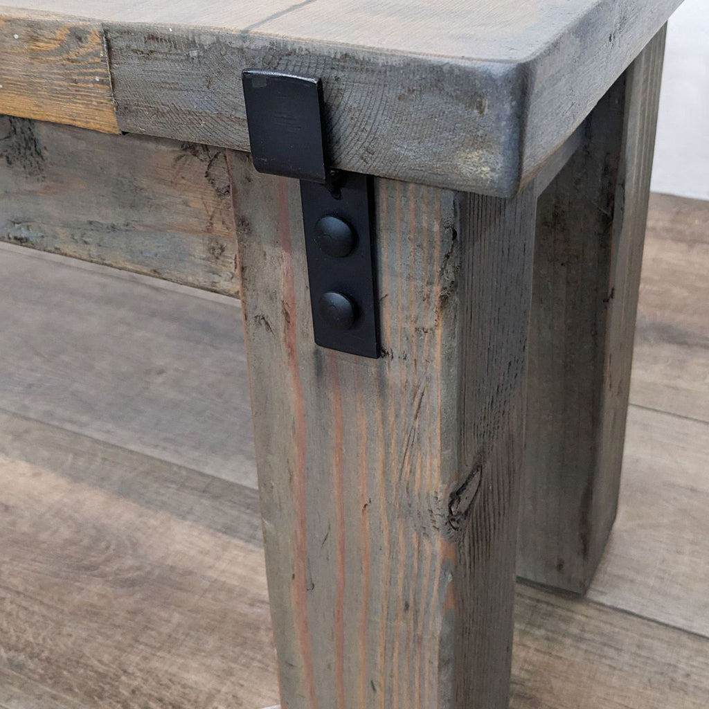 3. "Close-up of a National Rustic bench corner with visible black metal detailing on weathered solid wood."