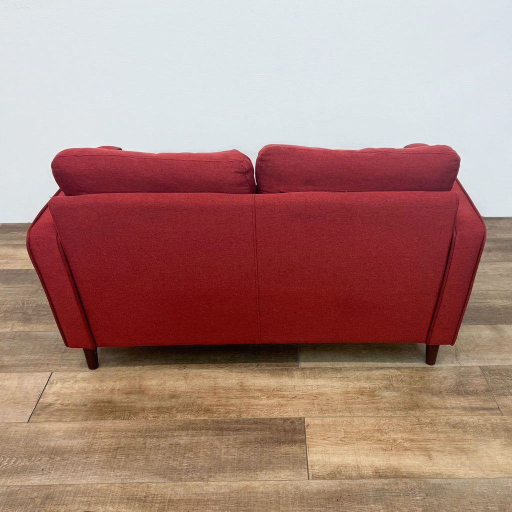 Back view of red loveseat showcasing two tufted cushions and narrow arm design.