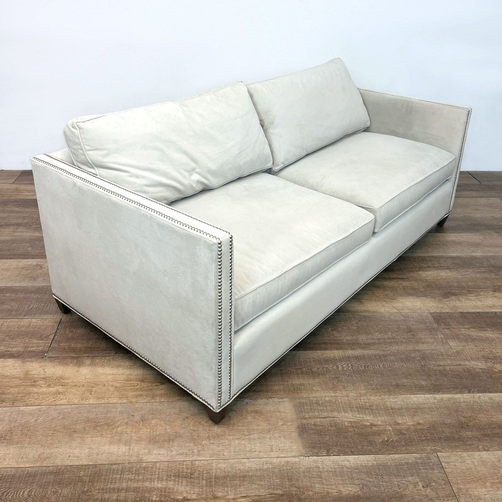 Side view of light gray sofa with narrow arms and sleek design.