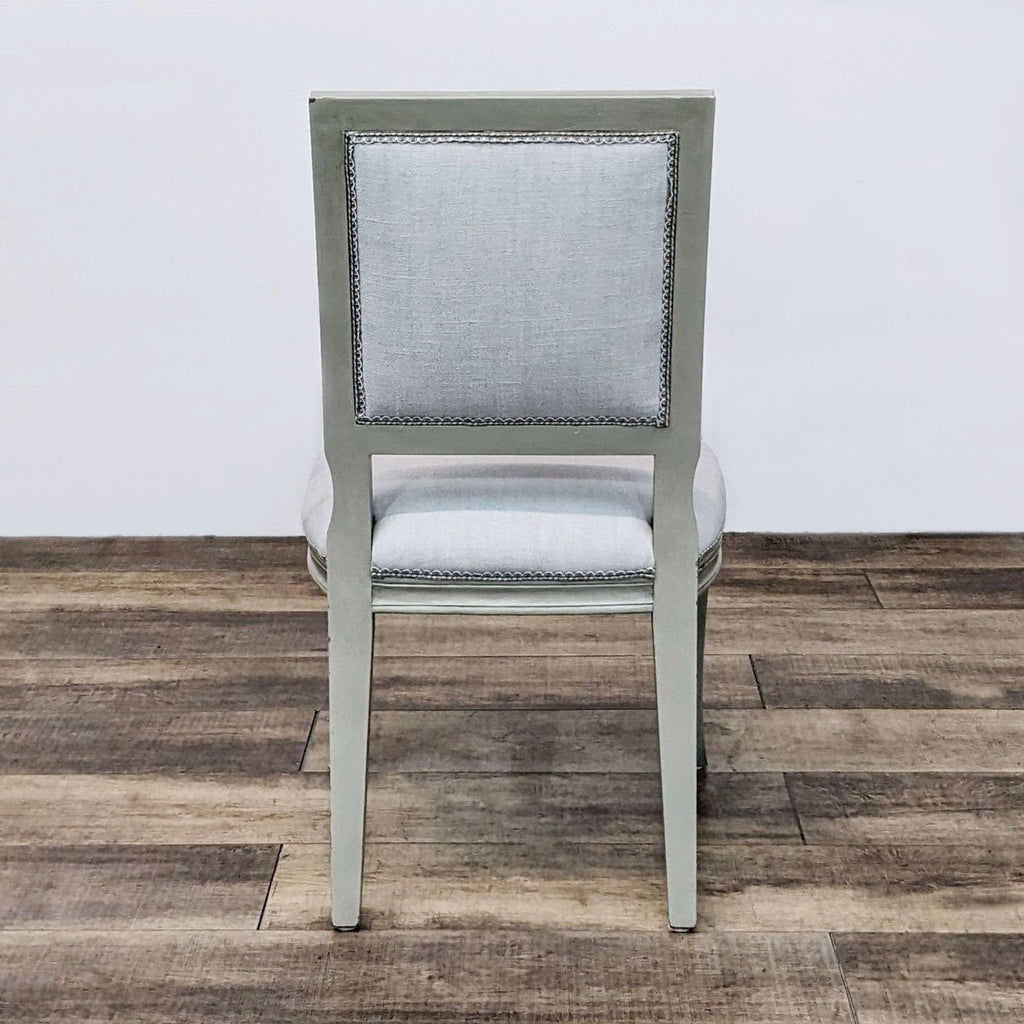 Back view of a vintage-inspired dining chair with upholstered backrest and wood frame.