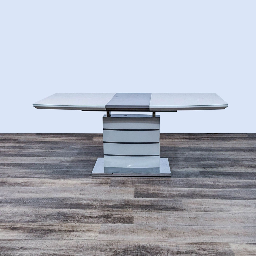 Glossy table with chrome accents, featuring a self-storing butterfly leaf and a polished base.
