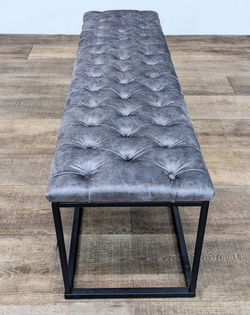 Long top view of a padded leather bench featuring a stylish metal frame.