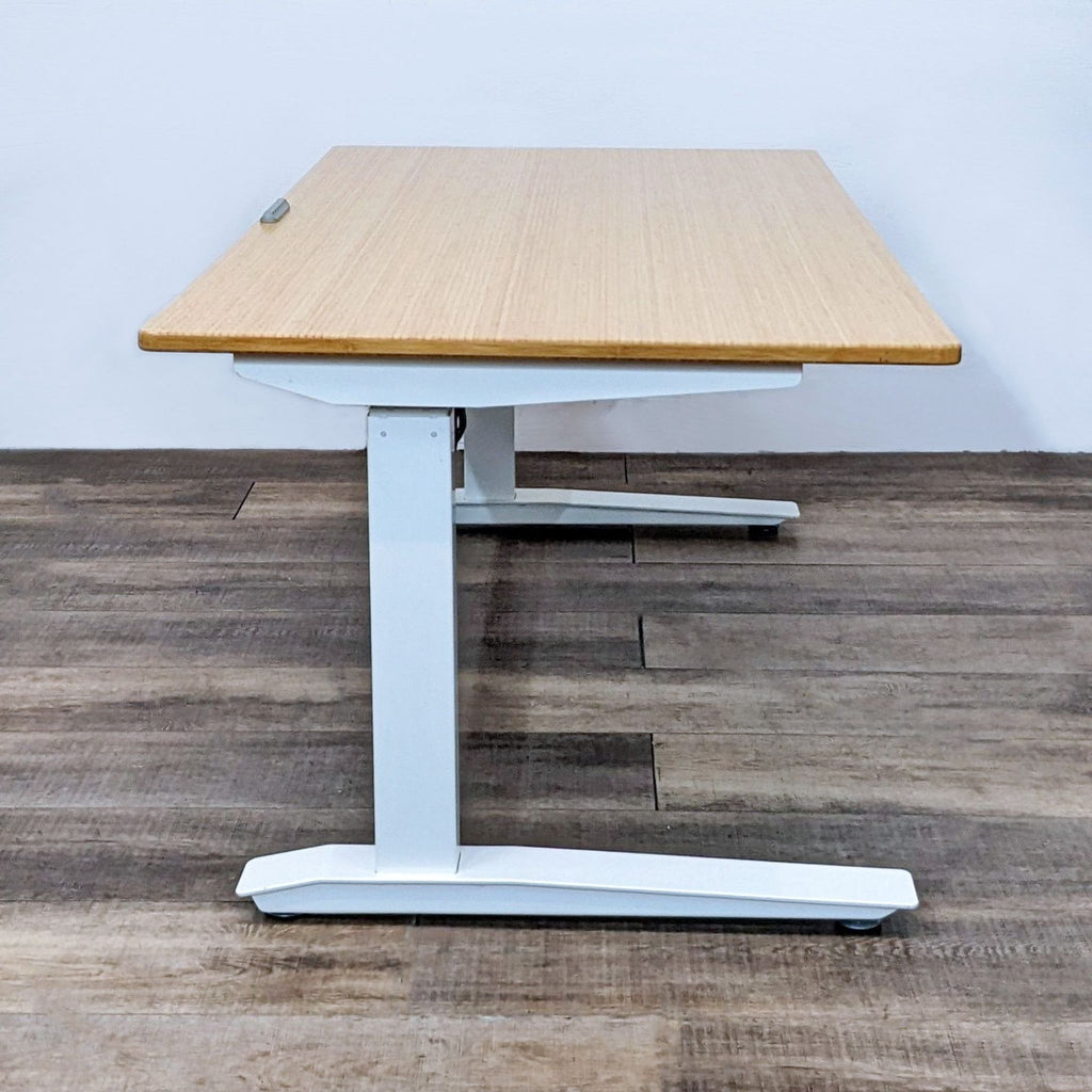 Side view of Jarvis desk showcasing bamboo top and sturdy white steel frame on wooden floor.