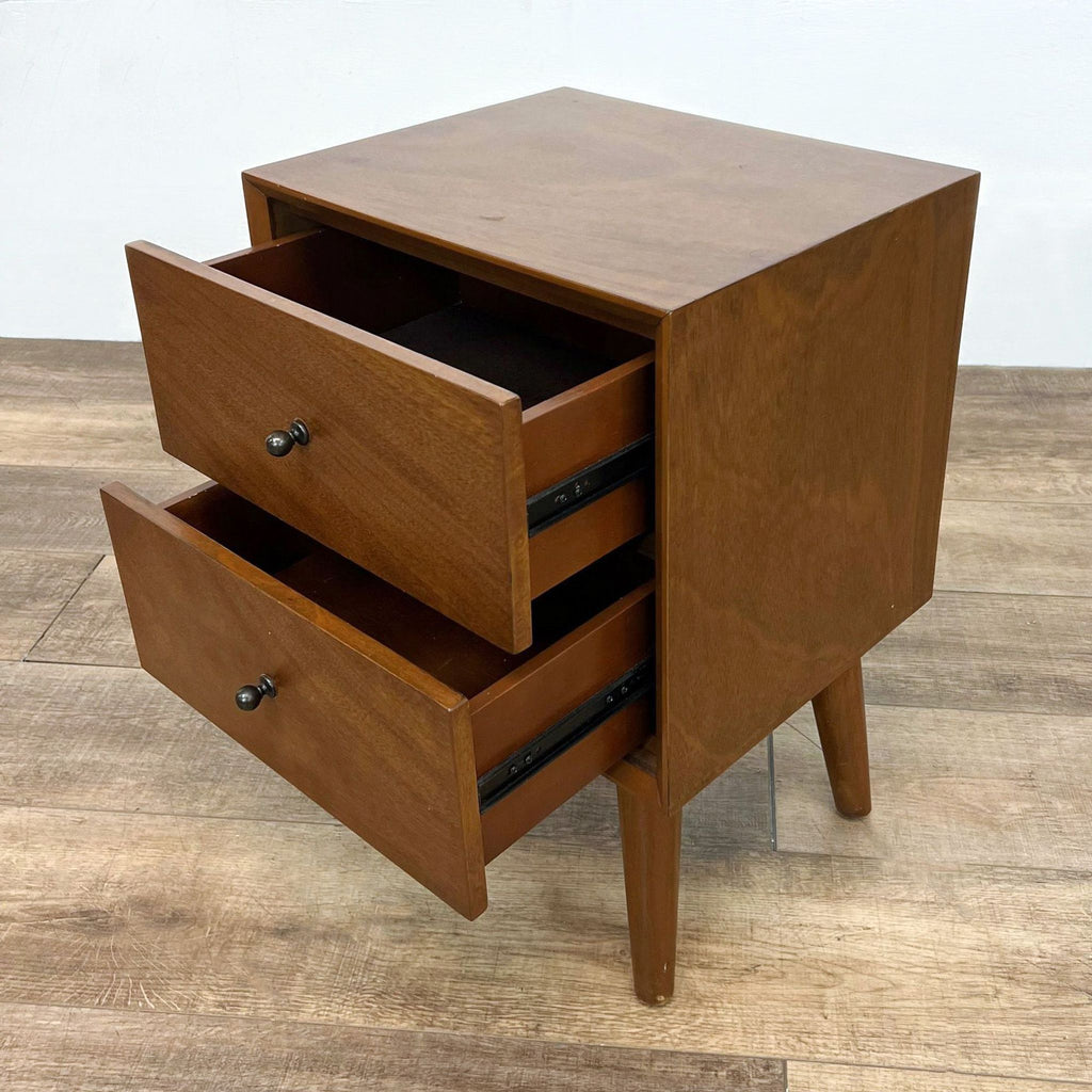Open drawers of Reperch end table on wooden floor.