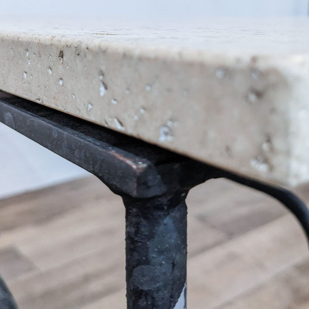 Detailed view of stone top edge on Reperch table showcasing metal construction.