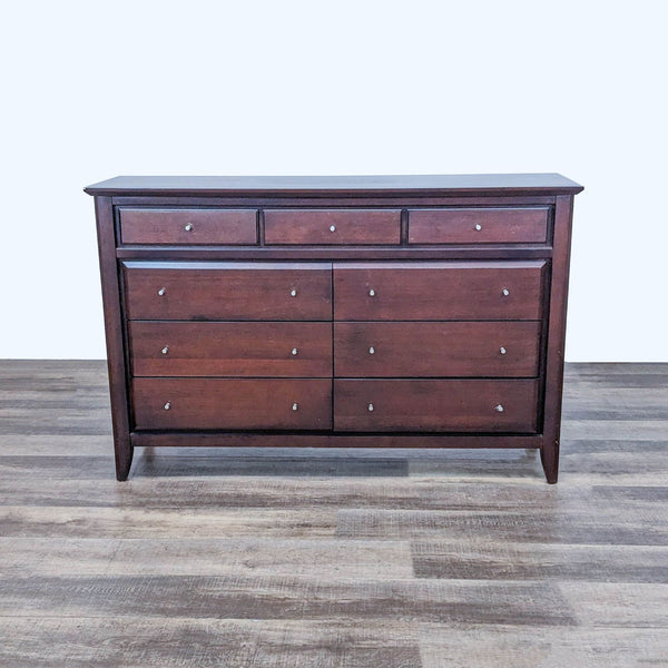 Front view of a walnut-finished dresser with nine drawers.  