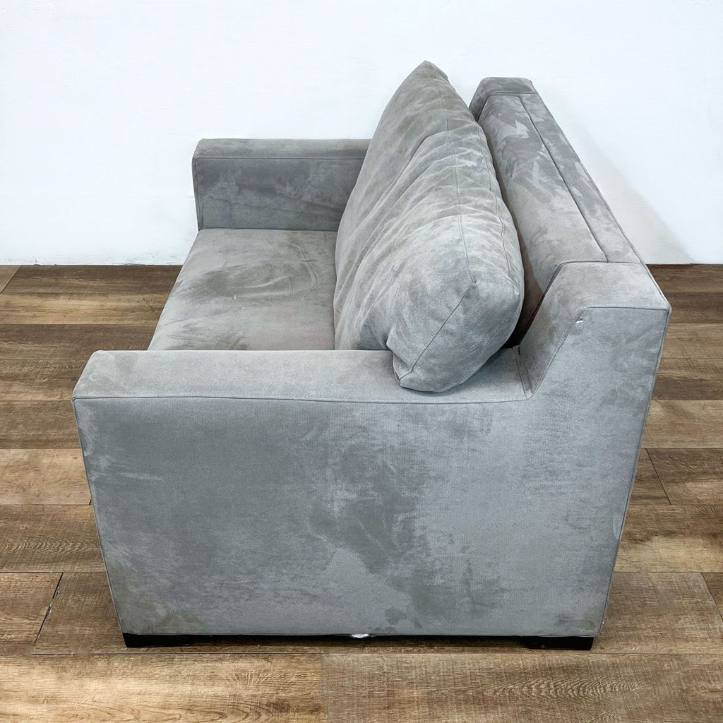 Side view of gray sleeper sofa with padded back cushions.