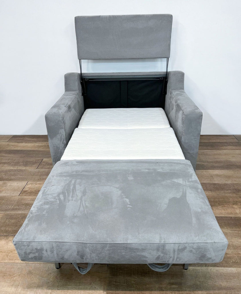 Gray sofa with fold-out mattress and adjustable headrest as a twin sleeper.