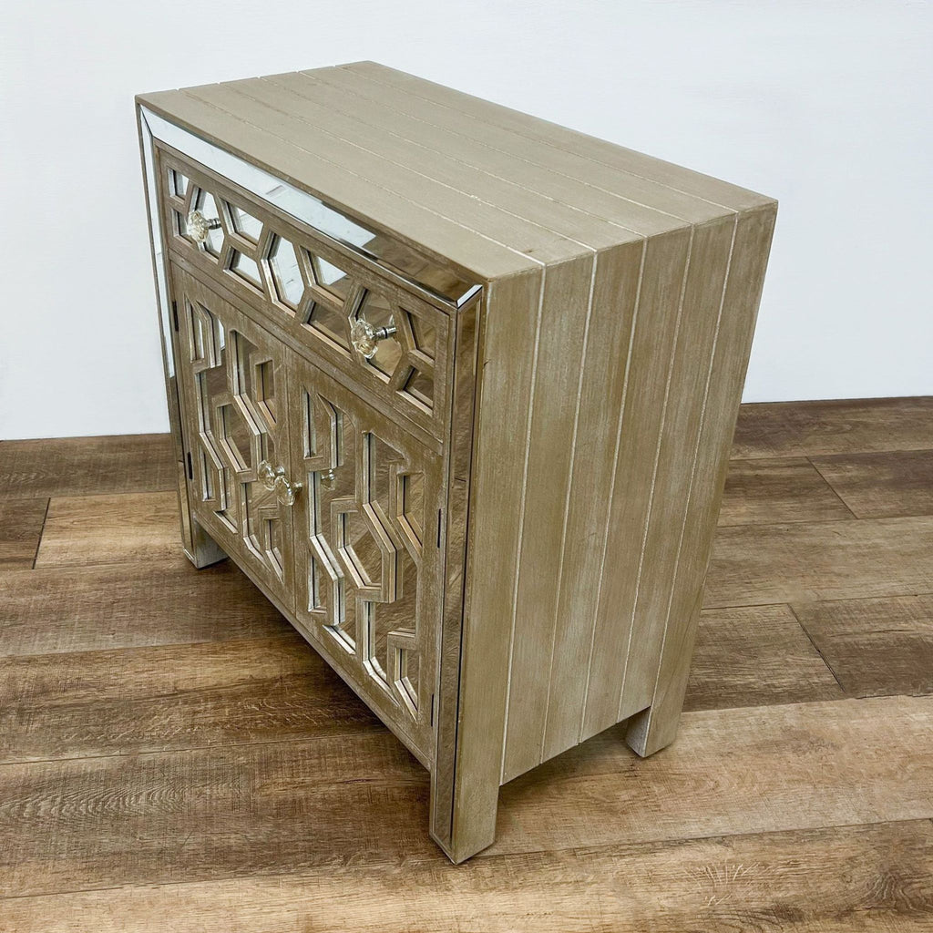 Whitewashed wood cabinet by Reperch featuring geometric cutouts and mirrored accents.