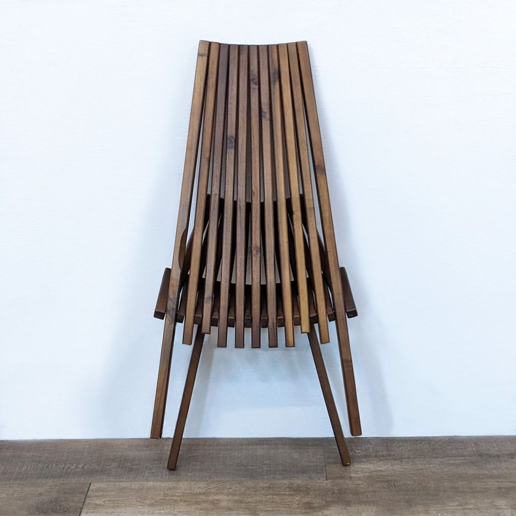 Side view of Reperch teak chair showing its sleek, angled legs.