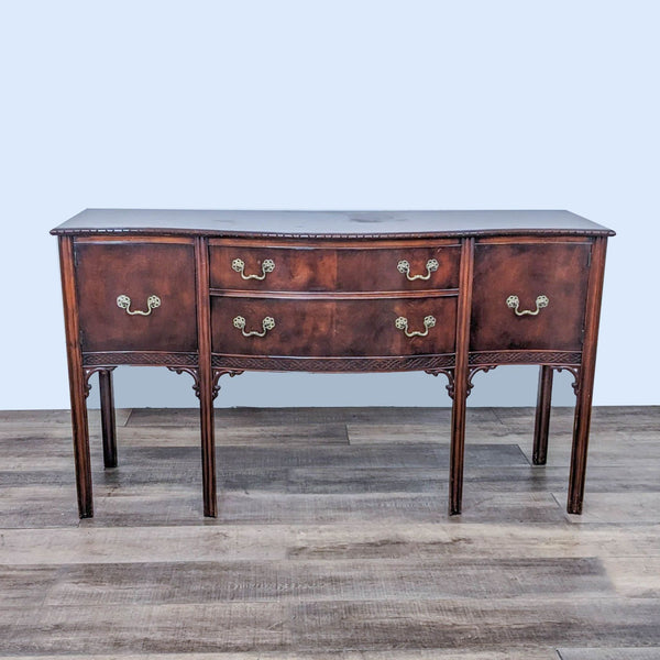 Elegant dark wood sideboard with curved drawers and ornate brass handles.