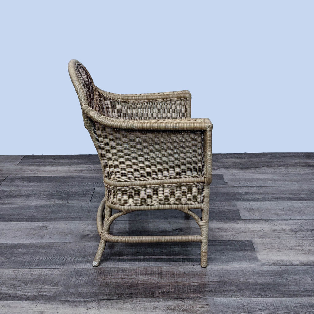 Side view of a wicker rattan armchair with a patterned cushion.