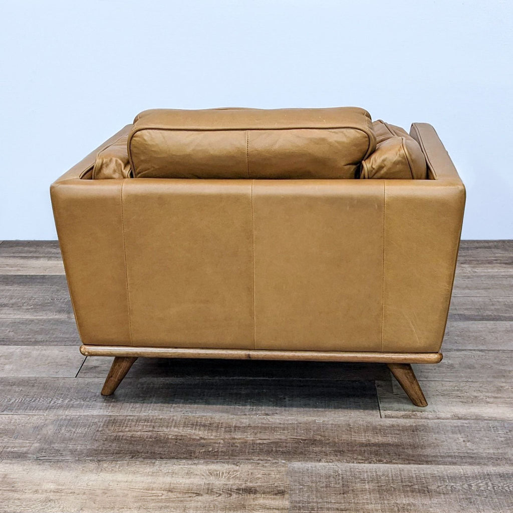 Back view of the Timber Charme chair showing its leather upholstery and wooden base by Article.