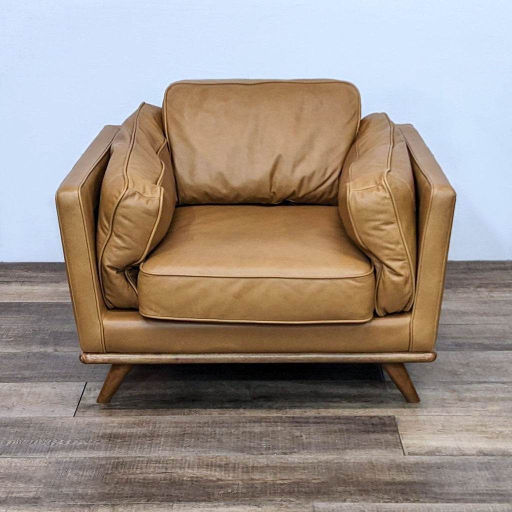 Front view of a Timber Charme lounge chair with leather cushions and oak trim by Article.  