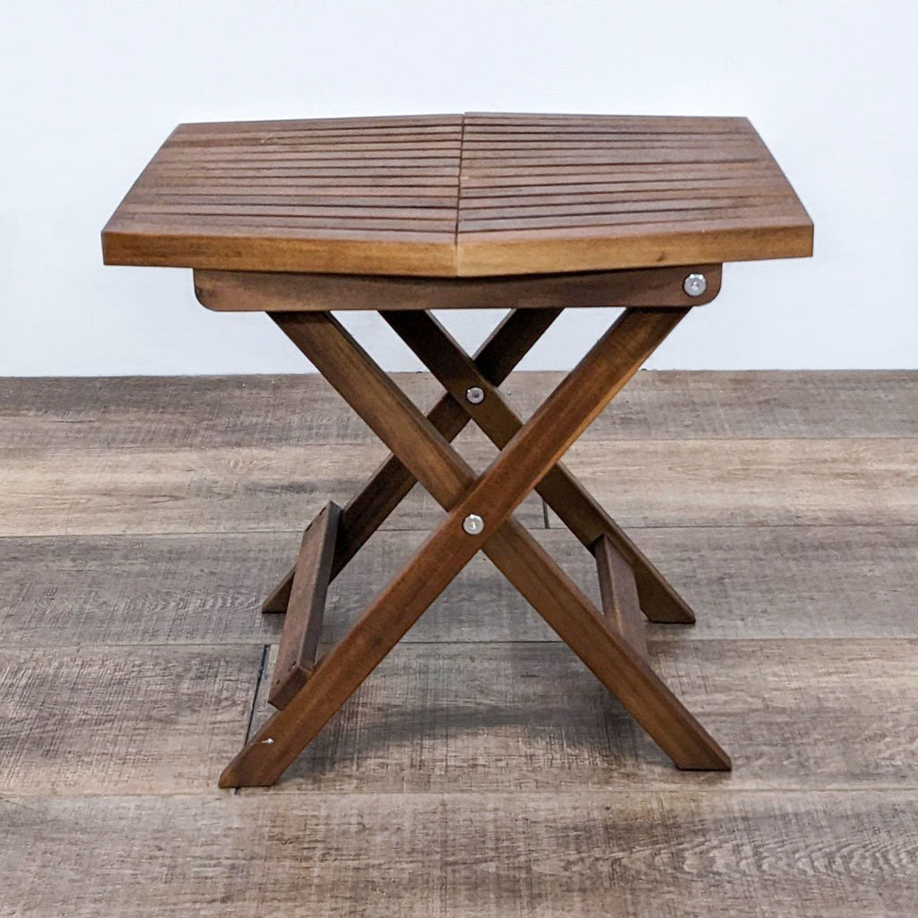 Solid teak wood table by Reperch, featuring a geometric slate design and collapsible legs for easy storage.