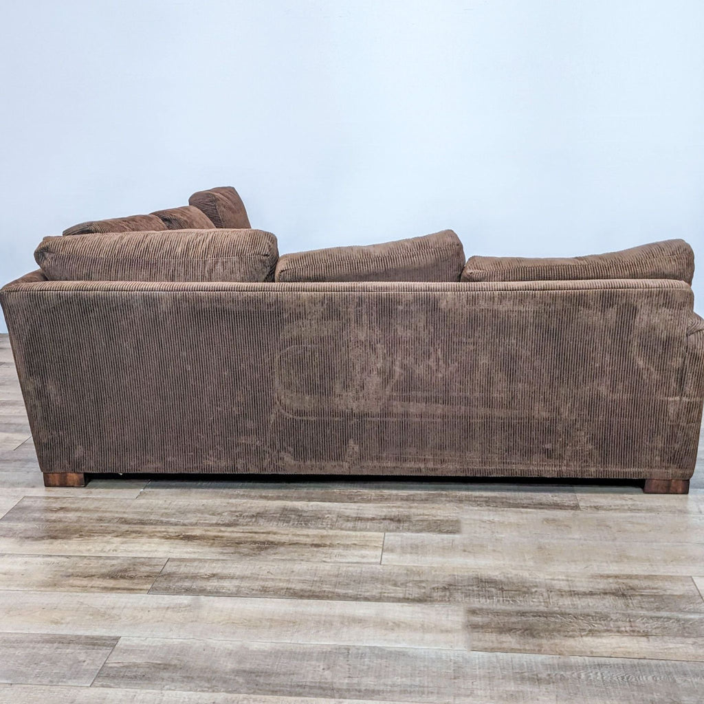 Modern brown sectional featuring plush cushions and wood finish feet.
