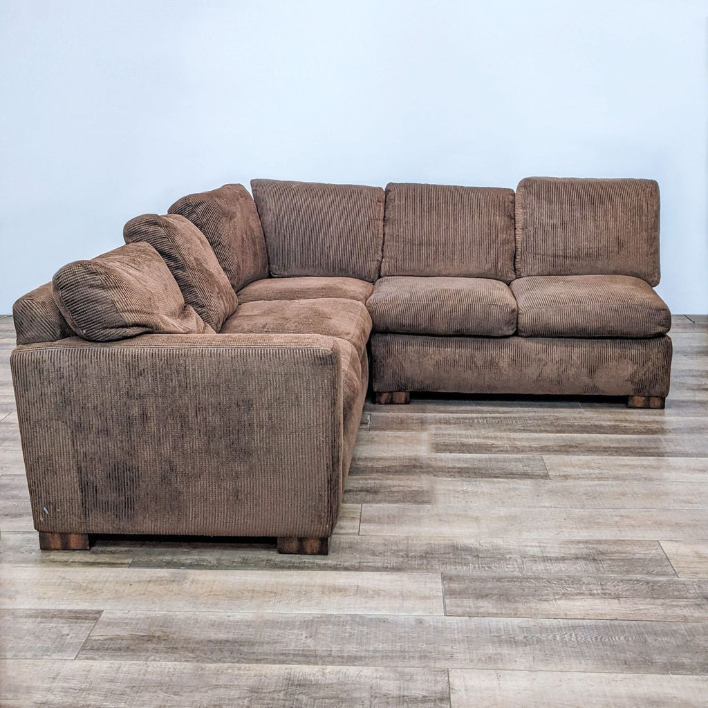 Contemporary brown sectional with down-wrapped cushions and wooden block feet.