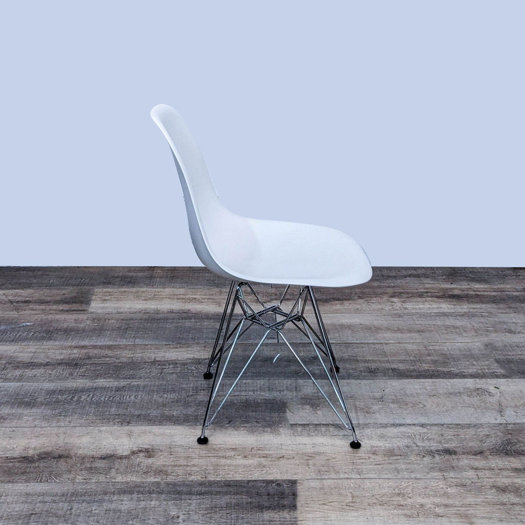 White Eames chair by Herman Miller, side profile, on wooden floor.