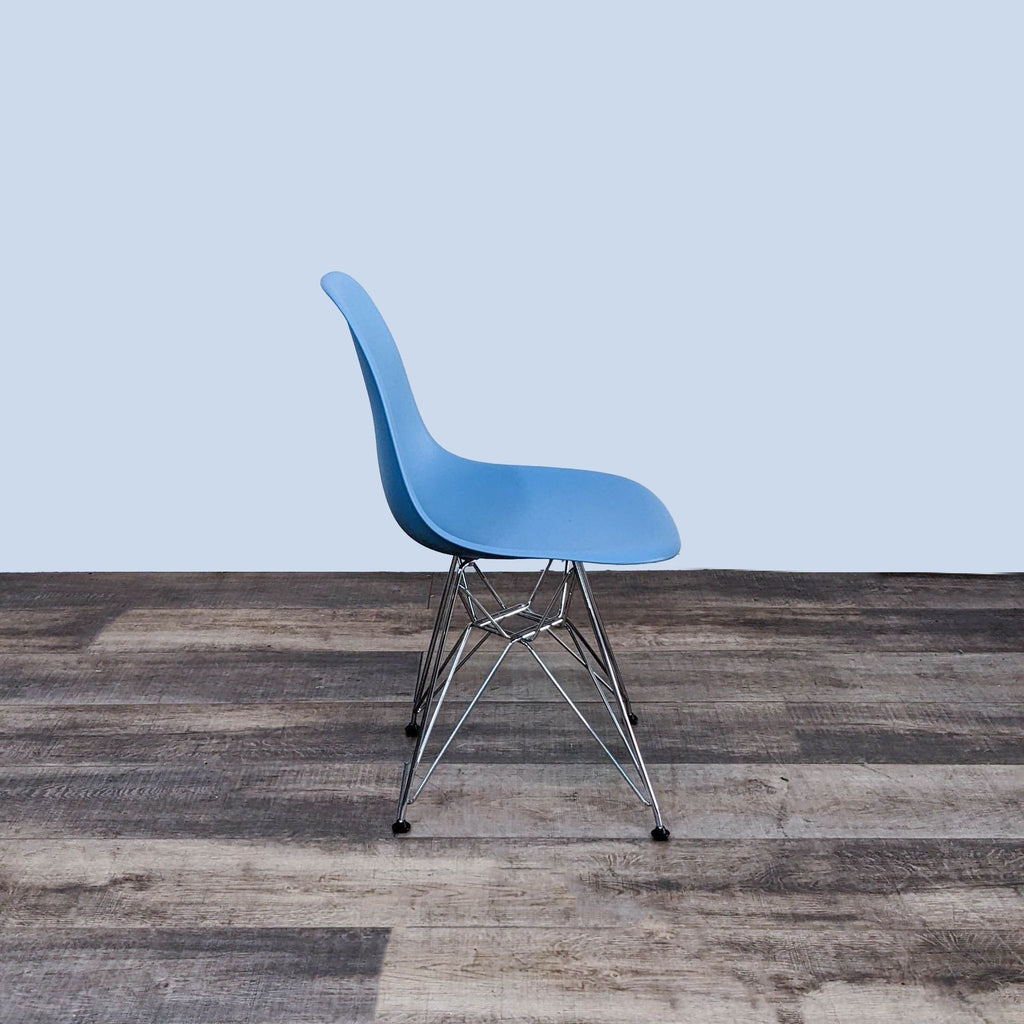 Side view of the Eames dining chair with a molded blue seat and chrome wire base.