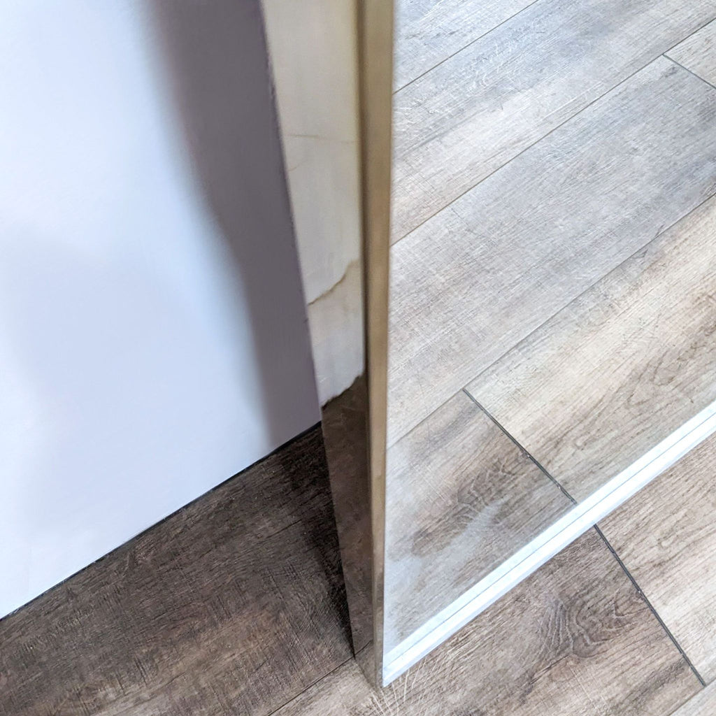 Close-up of mirror corner showcasing marble and brass design.