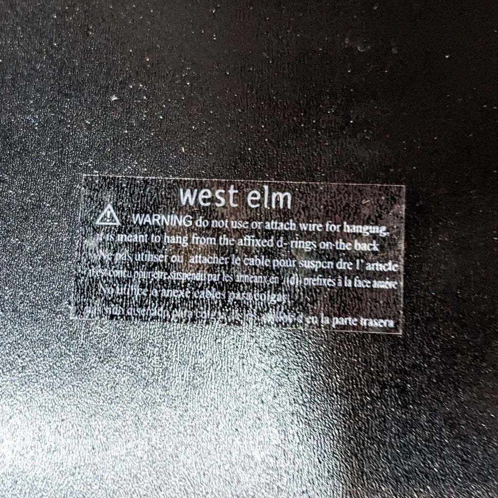 Label on back of West Elm mirror with hanging warning.