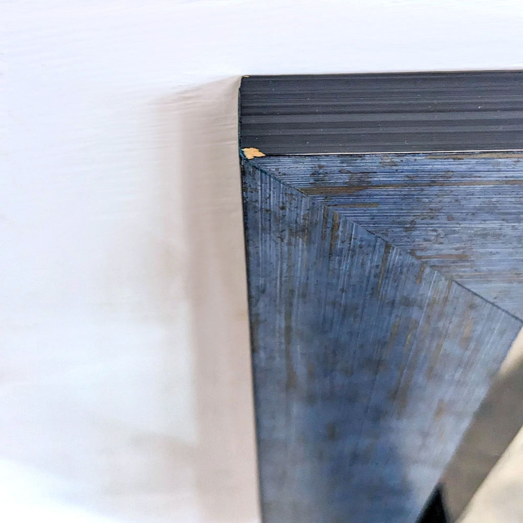 Close-up of the mirror's corner detailing the weathered frame texture.