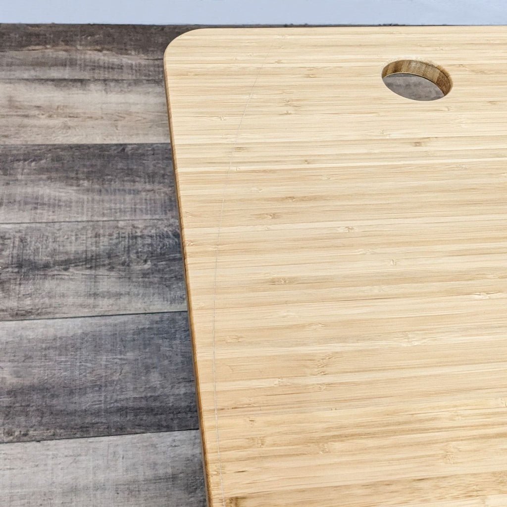 Close-up of bamboo desktop with cable management hole.
