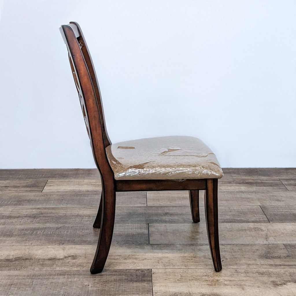 Side view of dining chair showing curved legs and upholstered seat.